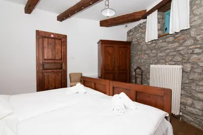 a bedroom with two beds and a stone wall at Apartments Valentinus 1800 in Sežana