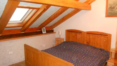 a bedroom with a bed in a room with wooden ceilings at Pri Macku in Tolmin