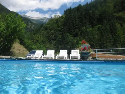 three white chairs sitting next to a swimming pool at Pri Macku in Tolmin