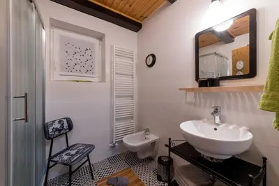 a white bathroom with a sink and a mirror at Cosy Hill Home Rucman With a Breathtaking View in Zgornja Pohanca