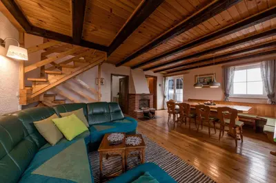 a living room with a couch and a dining room at Cosy Hill Home Rucman With a Breathtaking View in Zgornja Pohanca