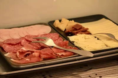 a tray of food with meat cheese and other foods at PONI NAKLO - Sobe Marinšek in Naklo