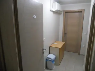 a small bathroom with a door and a trash can at Guest House Goršič in Grosuplje