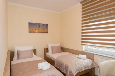 a small room with two beds and a window at Guest House Goršič in Grosuplje