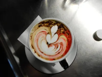 a cup of coffee with a heart painted on it at Guest House Goršič in Grosuplje