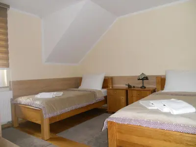 a bedroom with two beds and a table with a lamp at Guest House Goršič in Grosuplje