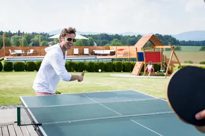 a man playing ping pong on a ping pong table at Holiday Residence Ana in Boršt