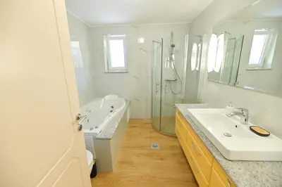 a bathroom with a sink and a shower and a tub at Holiday Residence Ana in Boršt
