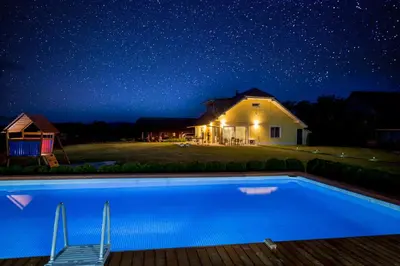 a house and a swimming pool at night at Holiday Residence Ana in Boršt