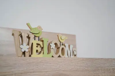 a wooden sign with a bird and the word welcome at Pri Neji in Postojna