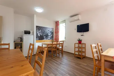 a kitchen and dining room with wooden tables and chairs at Yapka Rooms in Tolmin