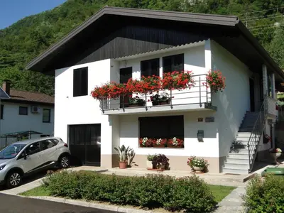 a white house with flowers on the balconies at Apartma Jezero in Most na Soči
