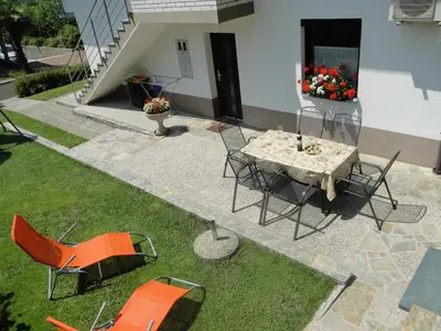 a table and chairs on the grass in front of a building at Apartma Jezero in Most na Soči