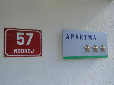 a sign on a wall with the number and aatta at Apartma Jezero in Most na Soči