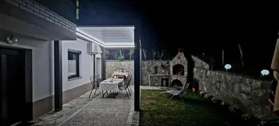 a backyard at night with a table and a fireplace at Apartma Jezero in Most na Soči