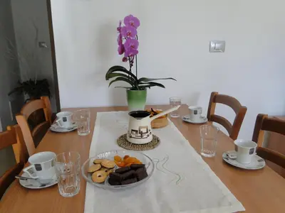 a table with a plate of cookies and a vase with purple flowers at Apartma Jezero in Most na Soči