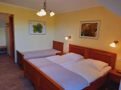 a bedroom with two beds and two lights on the wall at Turistična Kmetija Puklavec in Zasavci
