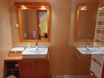 a bathroom with two sinks and a mirror at Turistična Kmetija Puklavec in Zasavci