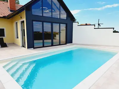 a swimming pool in front of a house at Turistična Kmetija Puklavec in Zasavci