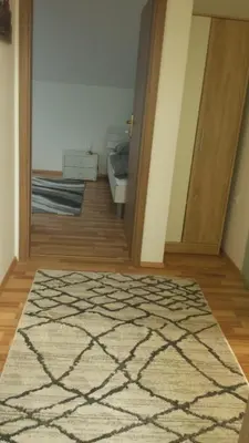 a room with a rug and a door with a bed at Apartma Rodica in Domžale