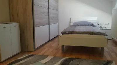 a bedroom with a bed and a dresser at Apartma Rodica in Domžale