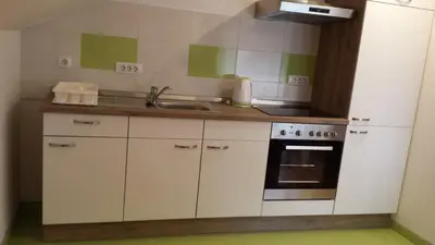 a kitchen with white cabinets and a sink and a stove at Apartma Rodica in Domžale