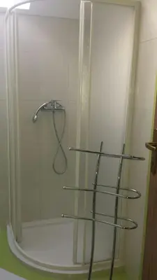 a shower with three glass shelves in a bathroom at Apartma Rodica in Domžale