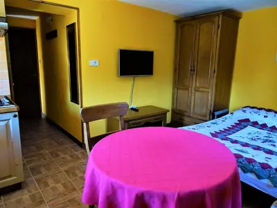a bedroom with a pink table and a bed at Apartmaji Pr-Gujlu Sela nad Podmelcem 5220 TOLMIN in Podmelec