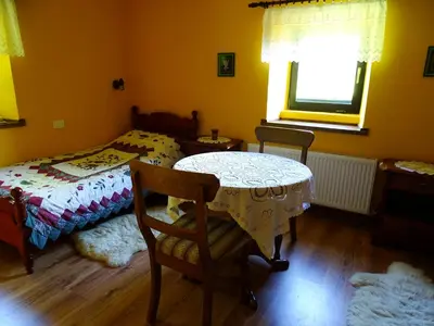 a bedroom with a table and a bed and a window at Apartmaji Pr-Gujlu Sela nad Podmelcem 5220 TOLMIN in Podmelec