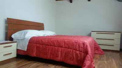 a bedroom with a bed with a red blanket and a dresser at Apartments Vila Bovec in Bovec