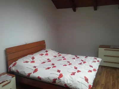 a bedroom with a bed with red flowers on it at Apartments Vila Bovec in Bovec