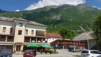 a town with cars parked in front of a mountain at Apartments Vila Bovec in Bovec