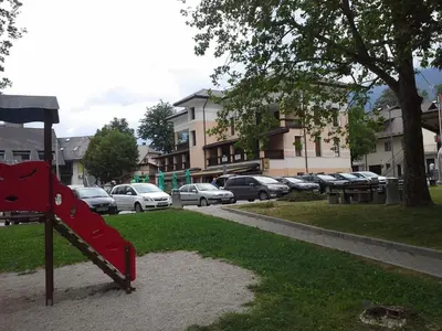 a playground with a red slide in a park at Apartments Vila Bovec in Bovec