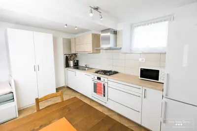 a kitchen with white cabinets and a stove top oven at Amber STUDIO in Kobarid