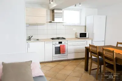 a kitchen with white cabinets and a table and a stove at Amber STUDIO in Kobarid
