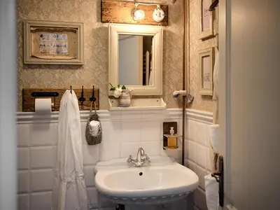 a white bathroom with a sink and a mirror at HOTEL StDaniel in Štanjel