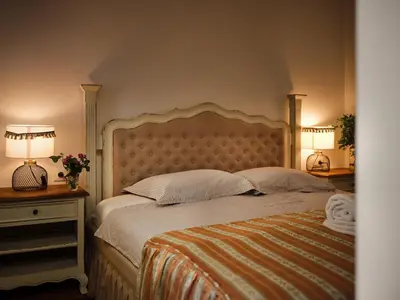 a bedroom with a bed with two lamps and two tables at HOTEL StDaniel in Štanjel