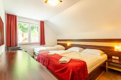 a hotel room with two beds and a window at Guest House Hober in Prevalje