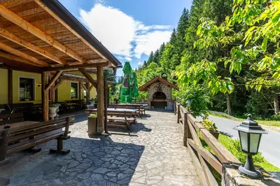 a group of wooden benches in front of a building at Guest House Hober in Prevalje
