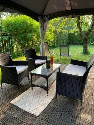 a patio with chairs and a table and an umbrella at Apartma Eli in Bled