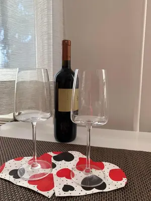 a bottle of wine and two wine glasses on a table at Apartma Eli in Bled