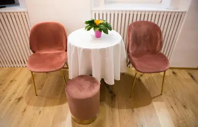 a table with a vase of flowers and three chairs at Codelli Deluxe City Centre Apartments in Ljubljana