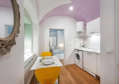 a kitchen with a table and two yellow chairs at Codelli Deluxe City Centre Apartments in Ljubljana