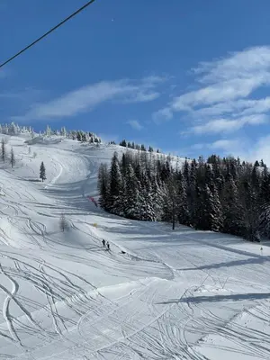 a snow covered slope with people skiing down a mountain at Velika Planina Koča Kekec in Stahovica