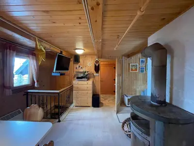 a room with a woodburning stove in a tiny house at Velika Planina Koča Kekec in Stahovica