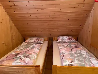 two beds in a cabin with wooden walls at Velika Planina Koča Kekec in Stahovica