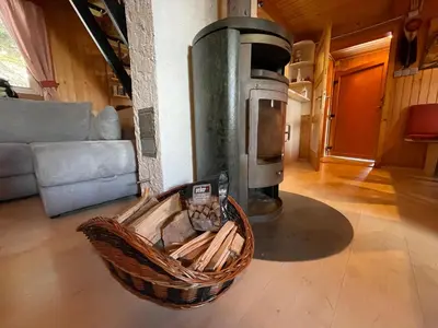 a wicker basket on the floor of a living room with a stove at Velika Planina Koča Kekec in Stahovica