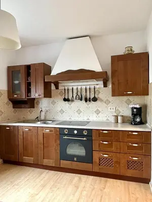 a kitchen with wooden cabinets and a blue stove top oven at House Natura with garden in Bovec