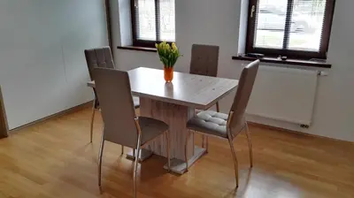 a dining room table with chairs and a vase of flowers on it at Gorenjka in Kranjska Gora