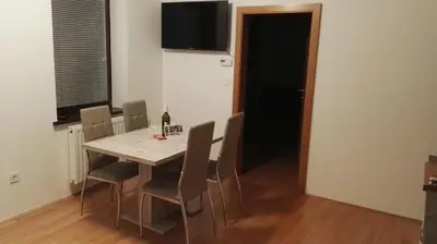 a dining room table with chairs and a bottle of wine at Gorenjka in Kranjska Gora